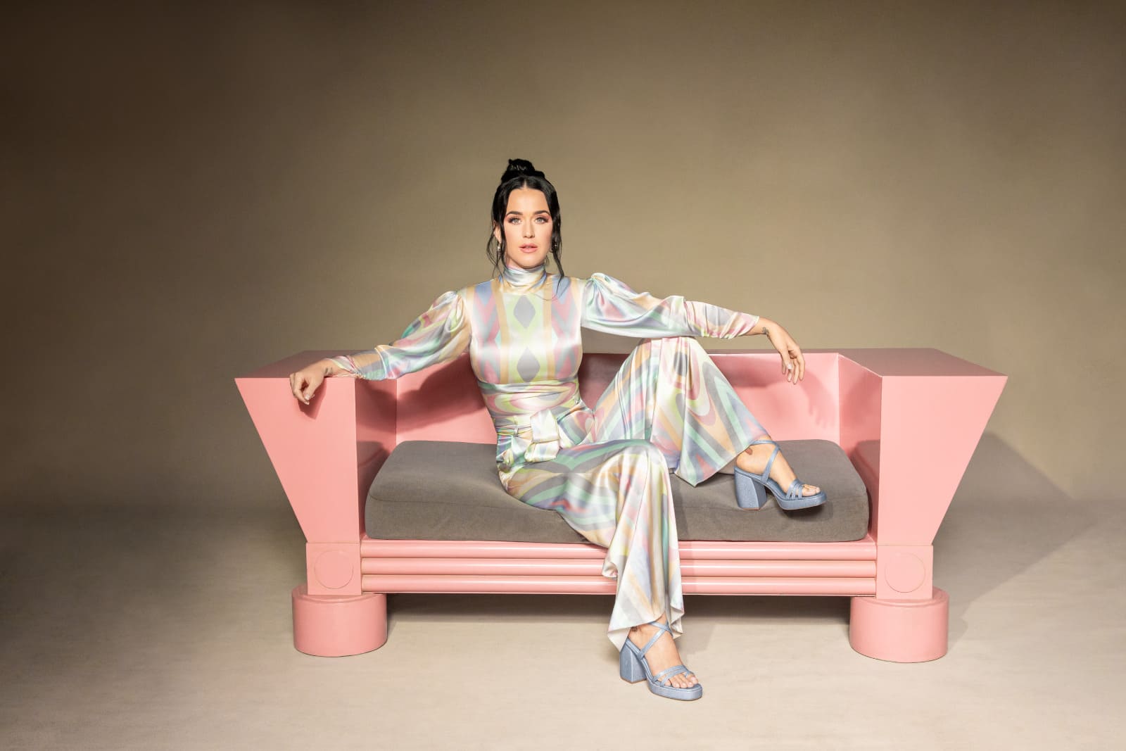 Katy Perry is sitting on a pink couch with a retro jumpsuit on.  Introducing Loyalty Points. Make a purchase- 5 points per $1 Create an account - 200 points Refer a friend - 500 points $10 voucher 500 points $20 voucher 1,000 points 15% off 500 points